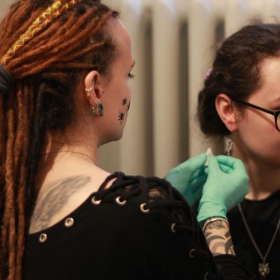 Piercerka prepichuje piercing ucha