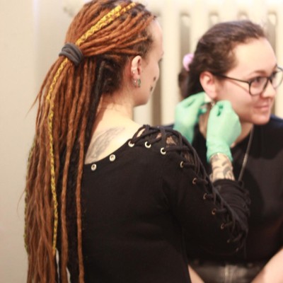 Piercerka prepichuje piercing ucha